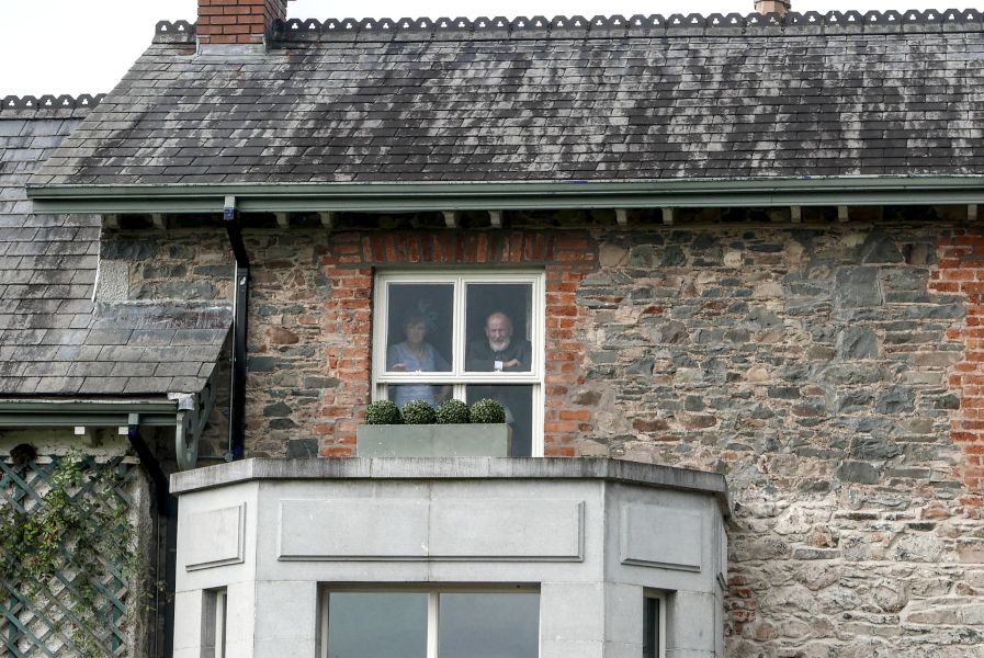 Parents of the groom staring out a window